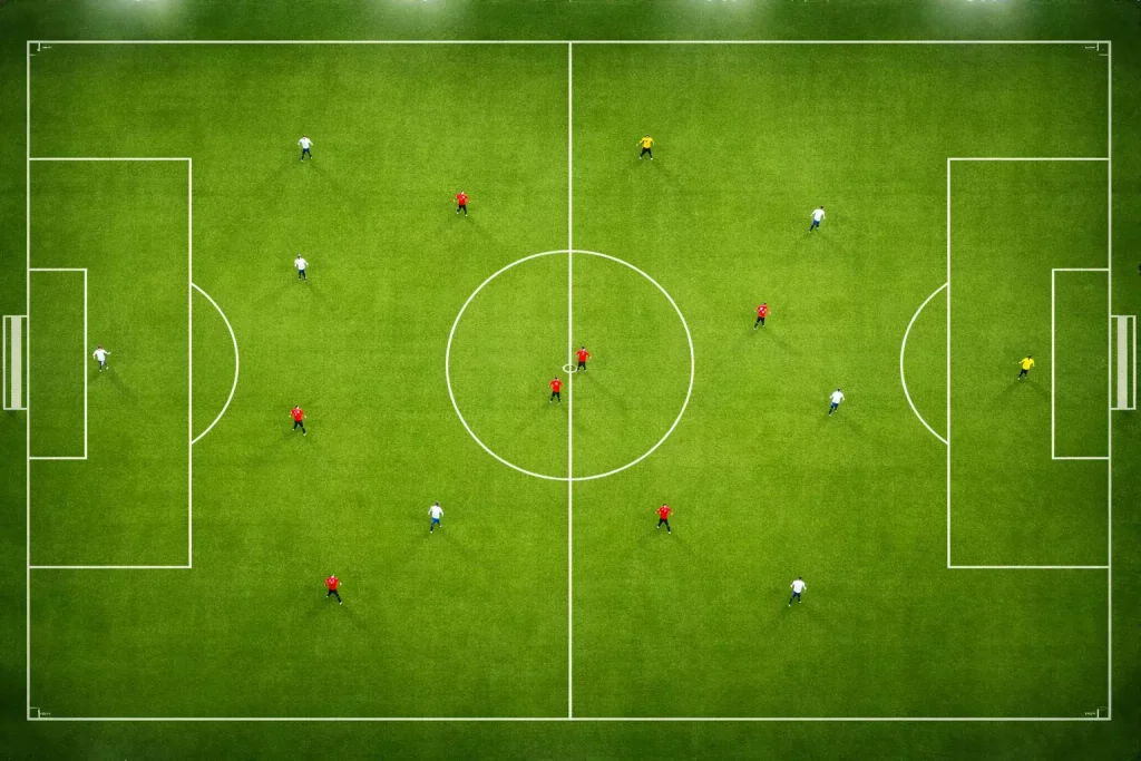 Vue plongeante sur un terrain de football pendant un match avec les lignes du terrain bien visibles
